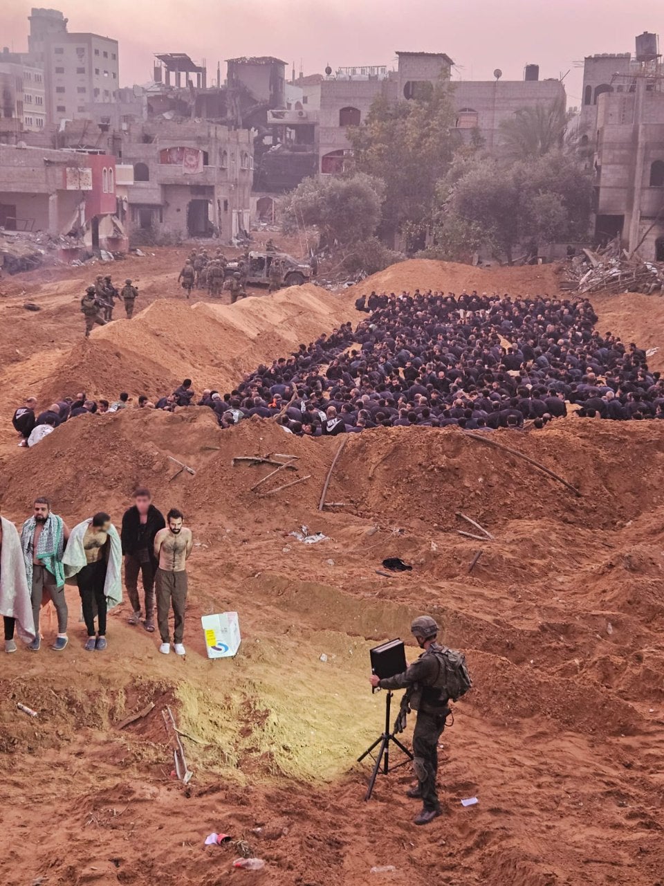 Dr. Khalid Hamoudeh (far left in the front) and Dr. Wadee Qasem (far right in the front) are detained along with other healthcare workers, internally displaced civilians, and patient’s families near the Kamal Adwan Hospital in northern Gaza, 2024.